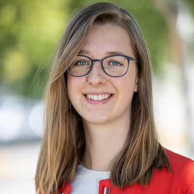 Eine Frau in roter Jacke und Brille