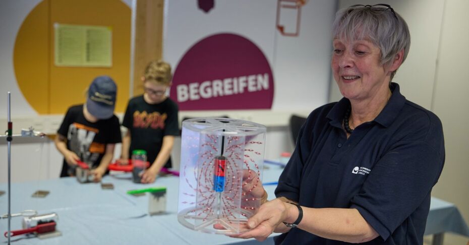 th_luebeck_juniorcampus_magnetfeldmodell Eine Mitarbeiterin vom Juniorcampus zeigt Magnetfeldmodell mit Eisenfeilspänen