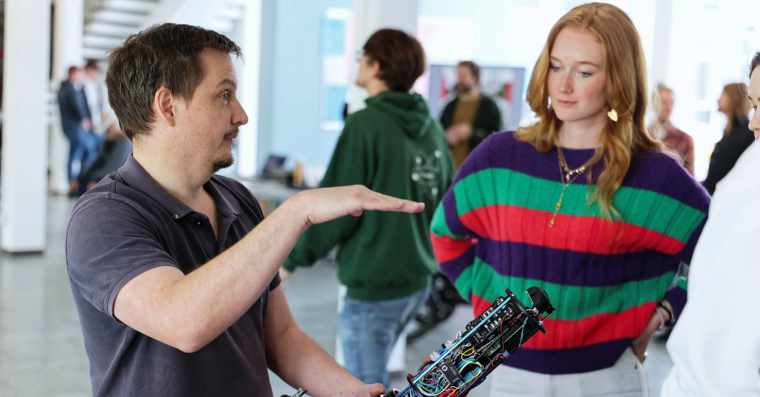 Zwei Personen reden miteinander über einen Roboter
