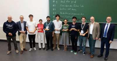 Gruppenbild in einer Reihe mit Menschen, die Preise halten