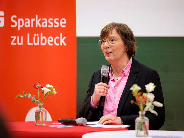 Ansprache der Innenministerin Eine Frau steht einem Tisch und spricht zu Menschen