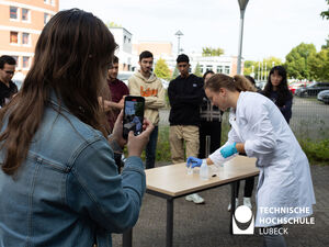 Mia Lahey-Rudolph (rechts) zeigt den Kollegiatinnen und Kollegiaten welche "Zutaten" sie für das sogenannte "Elephant Toothpaste" Experiment benötigen.