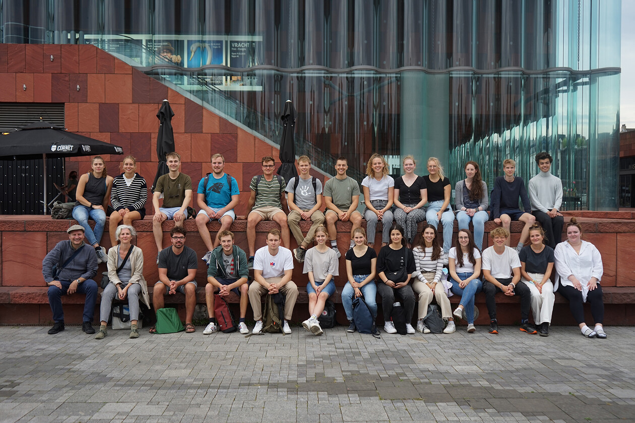 Gruppenfoto der Studierenden und Dozenten vor moderner Architektur.
