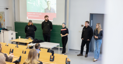 5 Studierende stehen im Hörsaal und erzählen Interessierten aus ihrem Alltag 