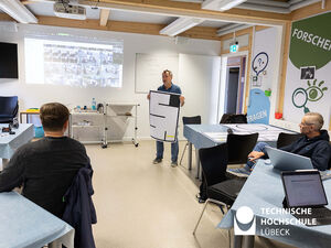 Prof. Jürgen Tchorz vom JuniorCampus der TH Lübeck zeigt das Labyrinth, durch das die Schüler*innen den Roboter steuern sollen. 