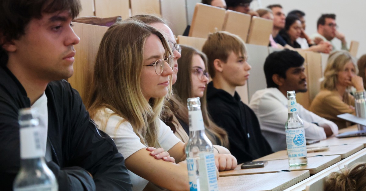 Reihe von Zuhörenden im Hörsaal verfolgt aufmerksam einen Vortrag