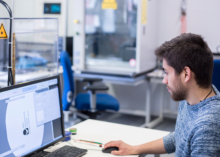 Mann sitzt an einem PC und arbeitet in CAD