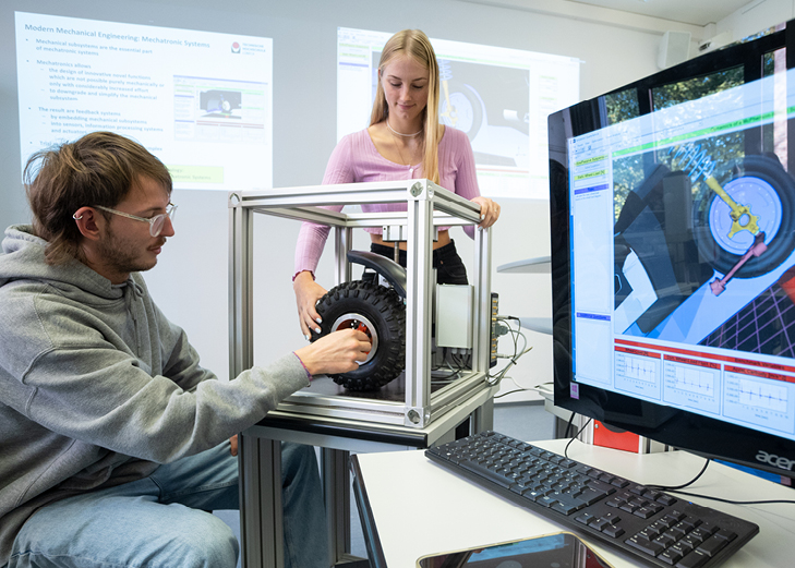Zwei Studierende arbeiten an einem Rad mit Sensoren