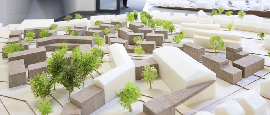 Architekturmodell einer Siedlung mit Häusern und kleinen Bäumen.