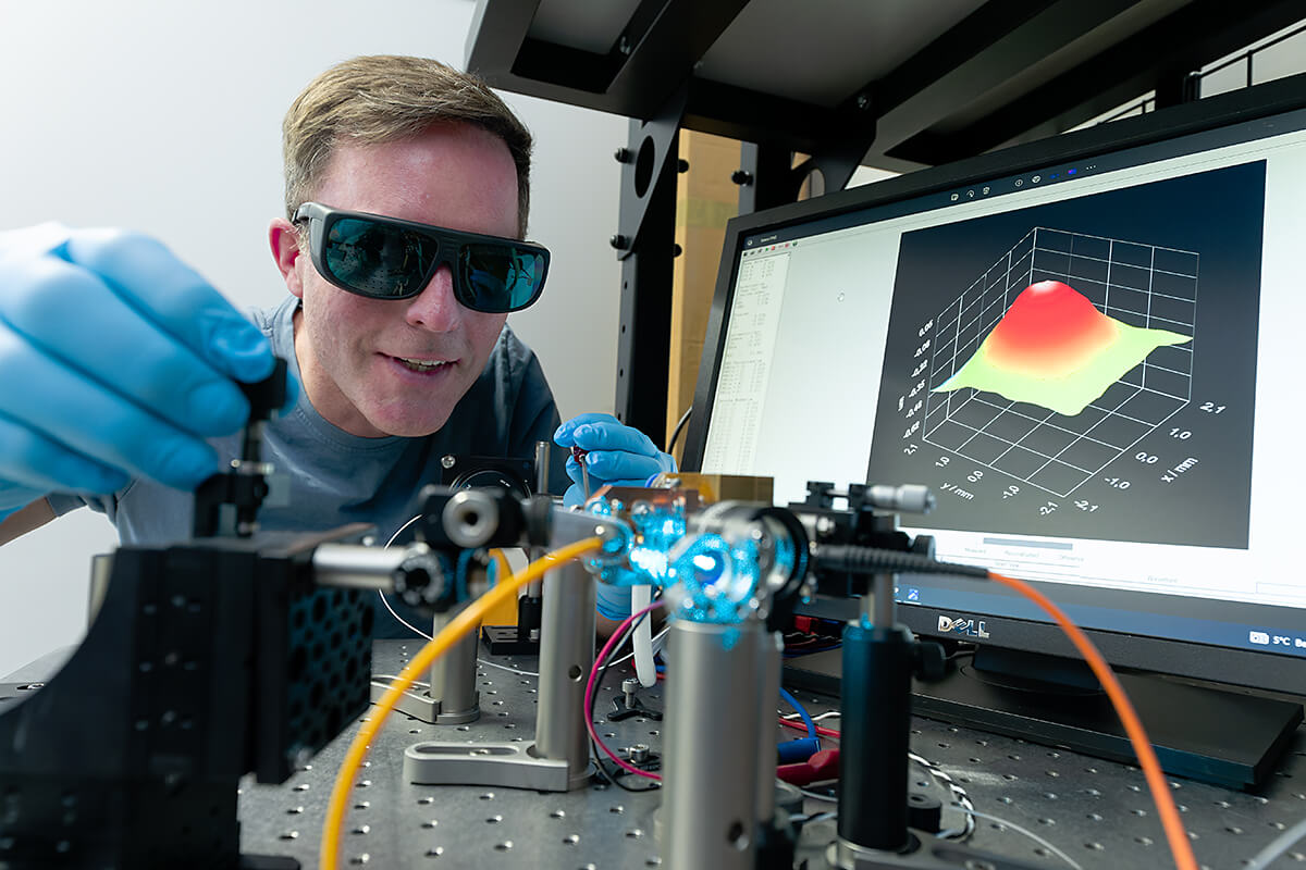 Foto Promovend Ein Forscher arbeitet an einem optischen Experiment mit Lasertechnik an der TH Lübeck.