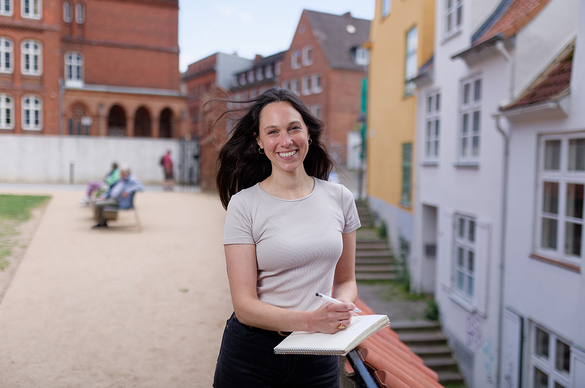 Foto Promovendin Foto zeigt lächelnde Frau mit schwarzen Haaren in Altstadt