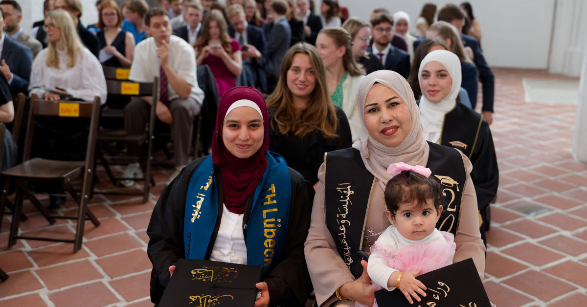 Frauen sitzen in Zweierreihen hintereinander