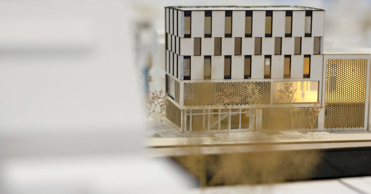 Architectural model of a multi-story, modern building with a lattice facade on the ground floor.