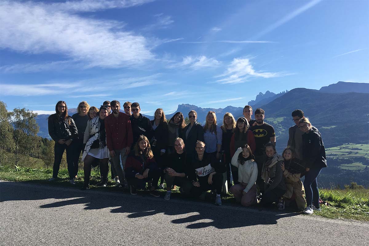 Gruppenfoto von Studierenden vor sonnigem Bergpanorama.
