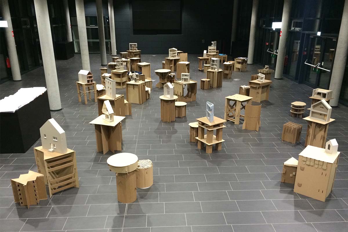 Ausstellung: Viele kleine Architekturmodelle auf Papp-Podesten in leerer Halle.