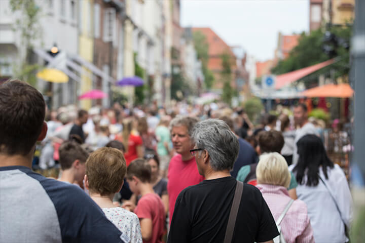 Die Lübecker Innenstadt lädt zum Schlendern und Bummeln ein. Besucher*innen in einer Einkaufsstraße.