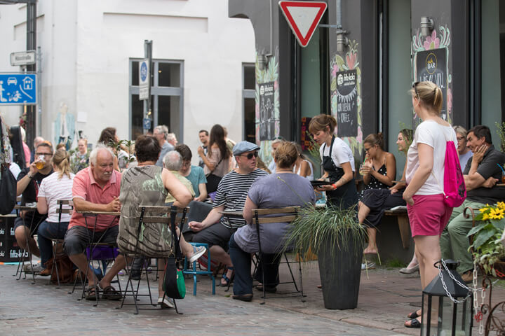 Menschen sitzen vor einem Café in der Lübecker Innenstadt