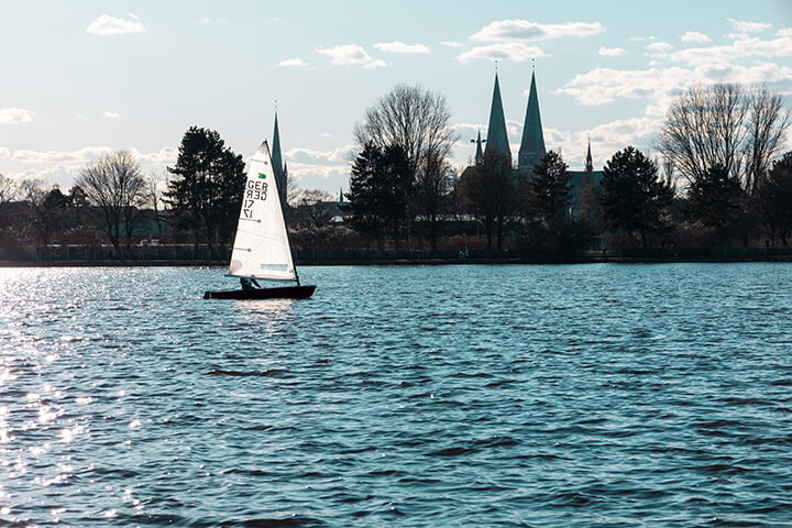 Ein Segler vor der Skyline der Lübecker Altstadt